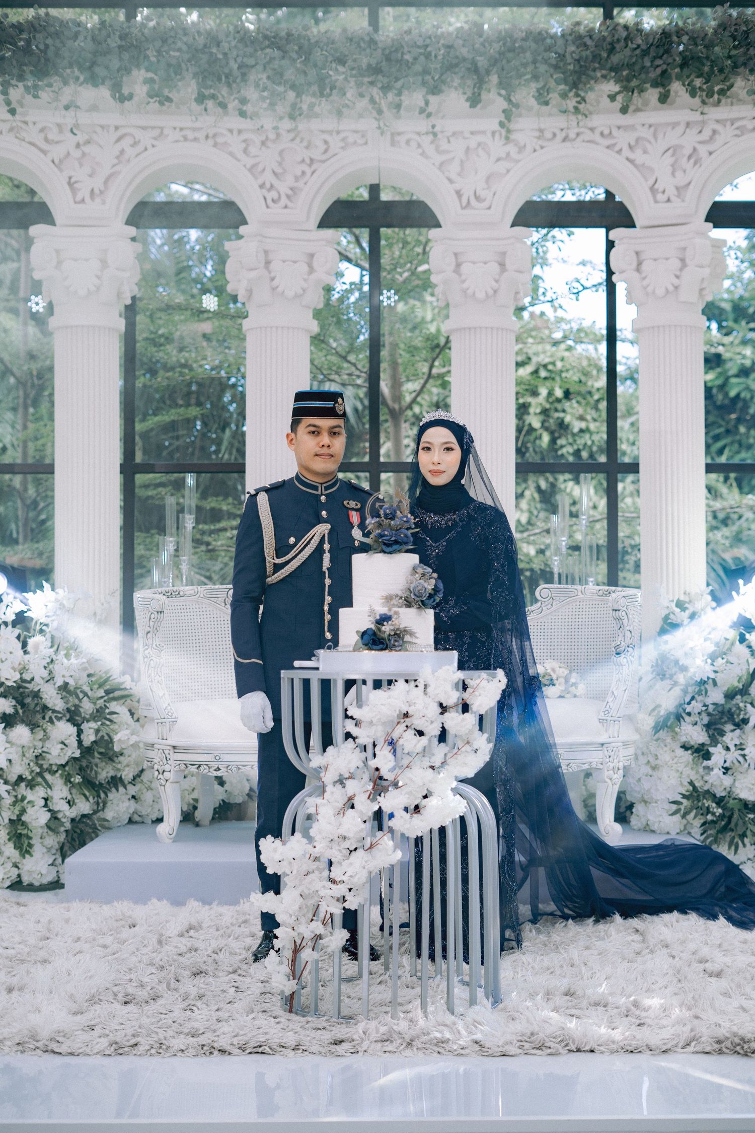 Romantic wedding photo session with elegant poses against white pillars and floral decorations in a dreamy outdoor setting.