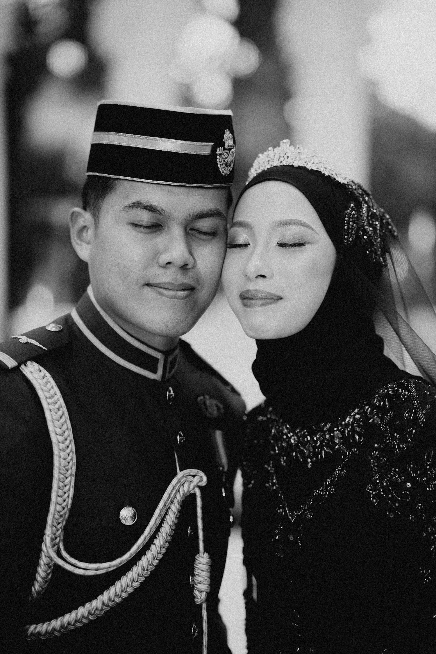 A tender black and white portrait of a military serviceman in full dress uniform with a woman in a sparkling hijab.