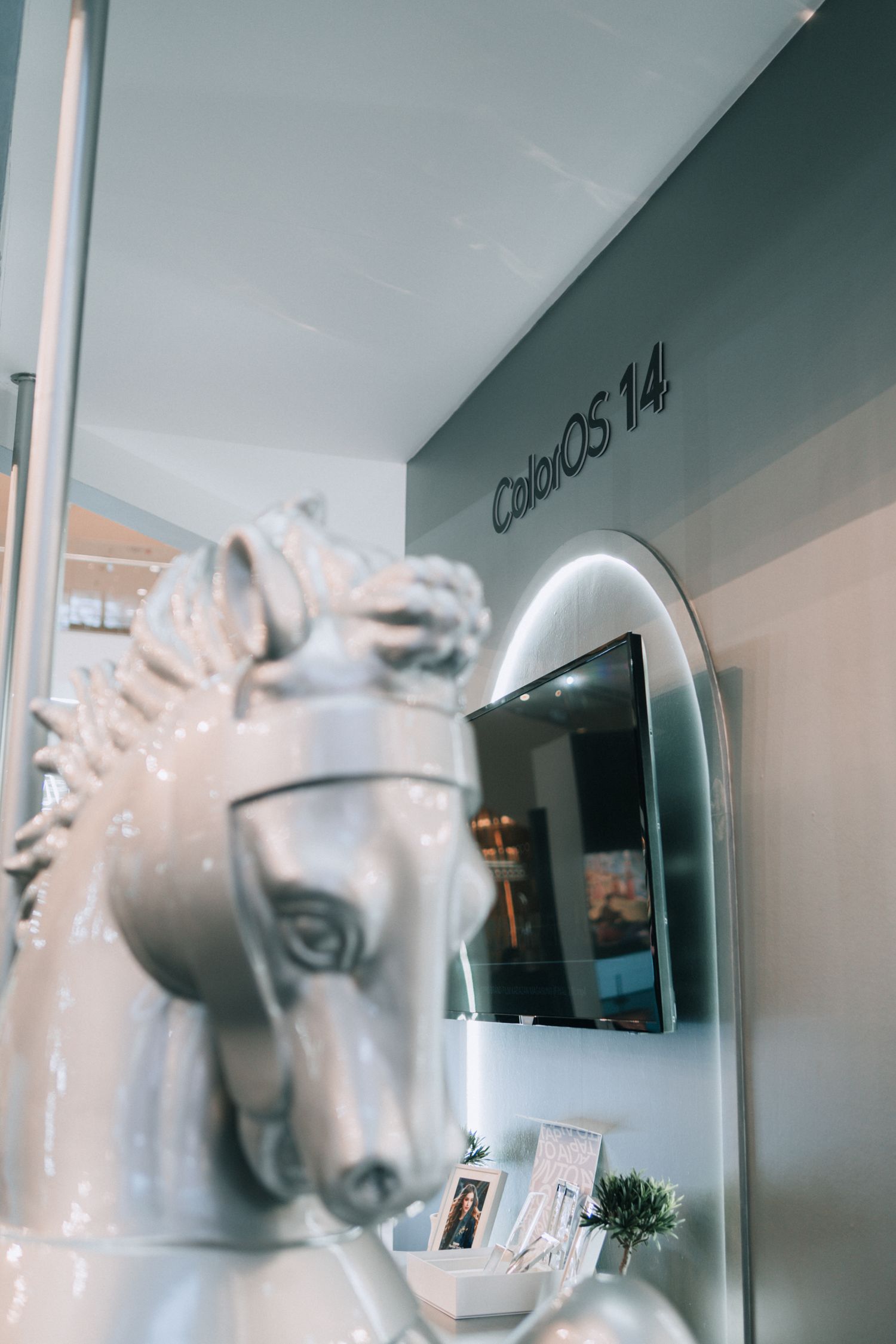 White decorative horse sculpture in front of a wall with a CabilOS 14 logo.