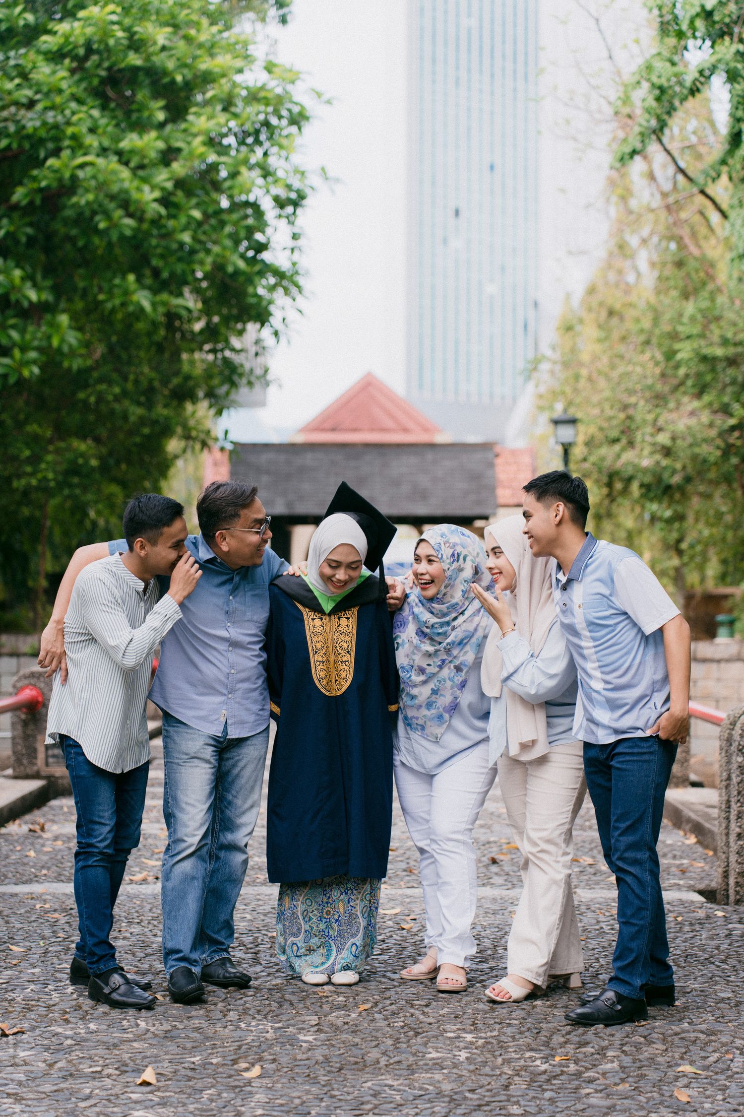 A playful group photo sequence showing people lined up and leaning on each other in a domino effect pose outdoors.