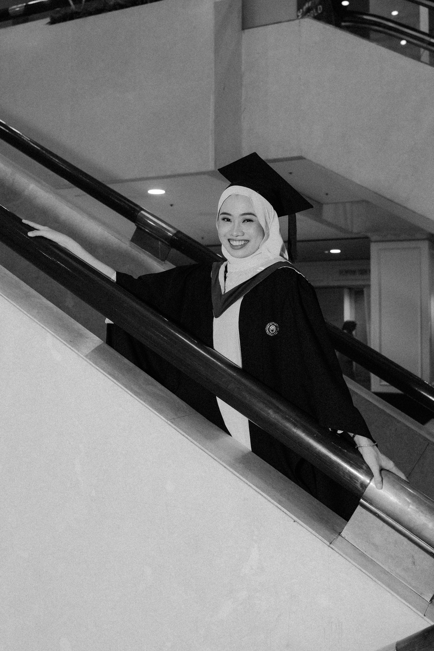 A series of black and white photographs showing someone descending an escalator, creating a repeating visual pattern.