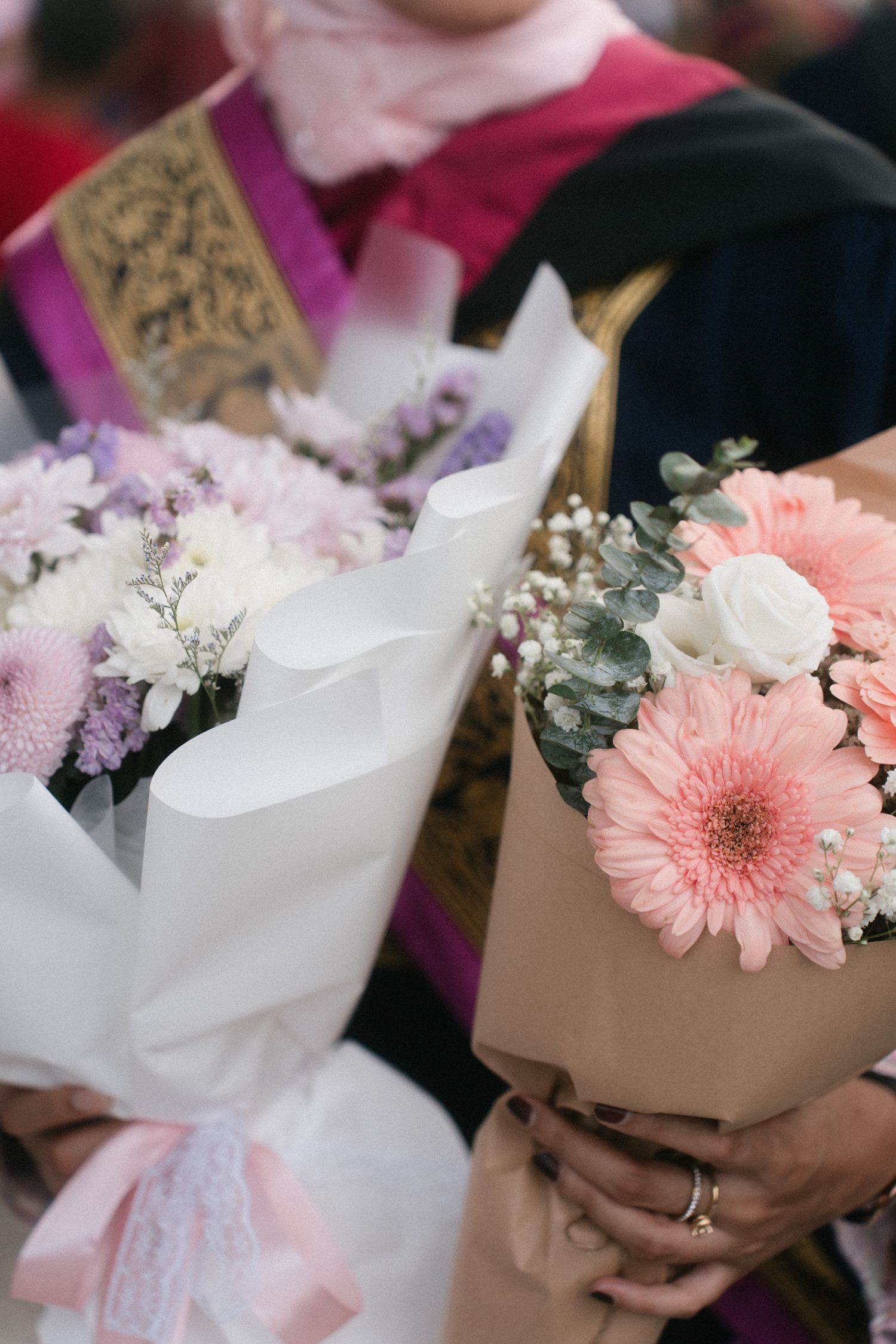 A series of delicate floral bouquets featuring pink gerbera daisies, white flowers, and baby's breath wrapped in paper.