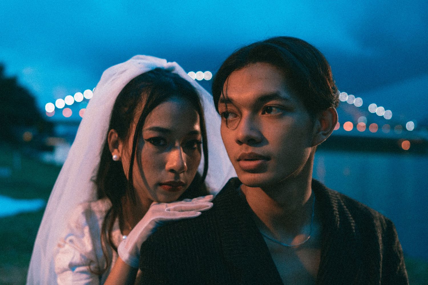 Evening portrait with blue lighting of couple in wedding attire.