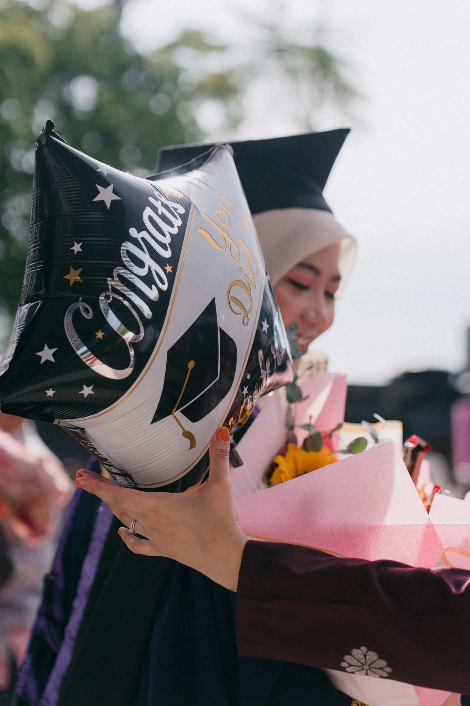 A row of people wearing black and white graduation caps shown in profile view during a ceremony.