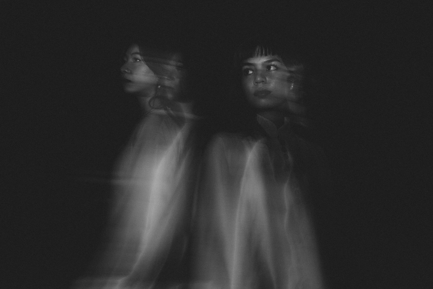 Artistic double exposure portrait creating ethereal ghost-like effect in black and white.
