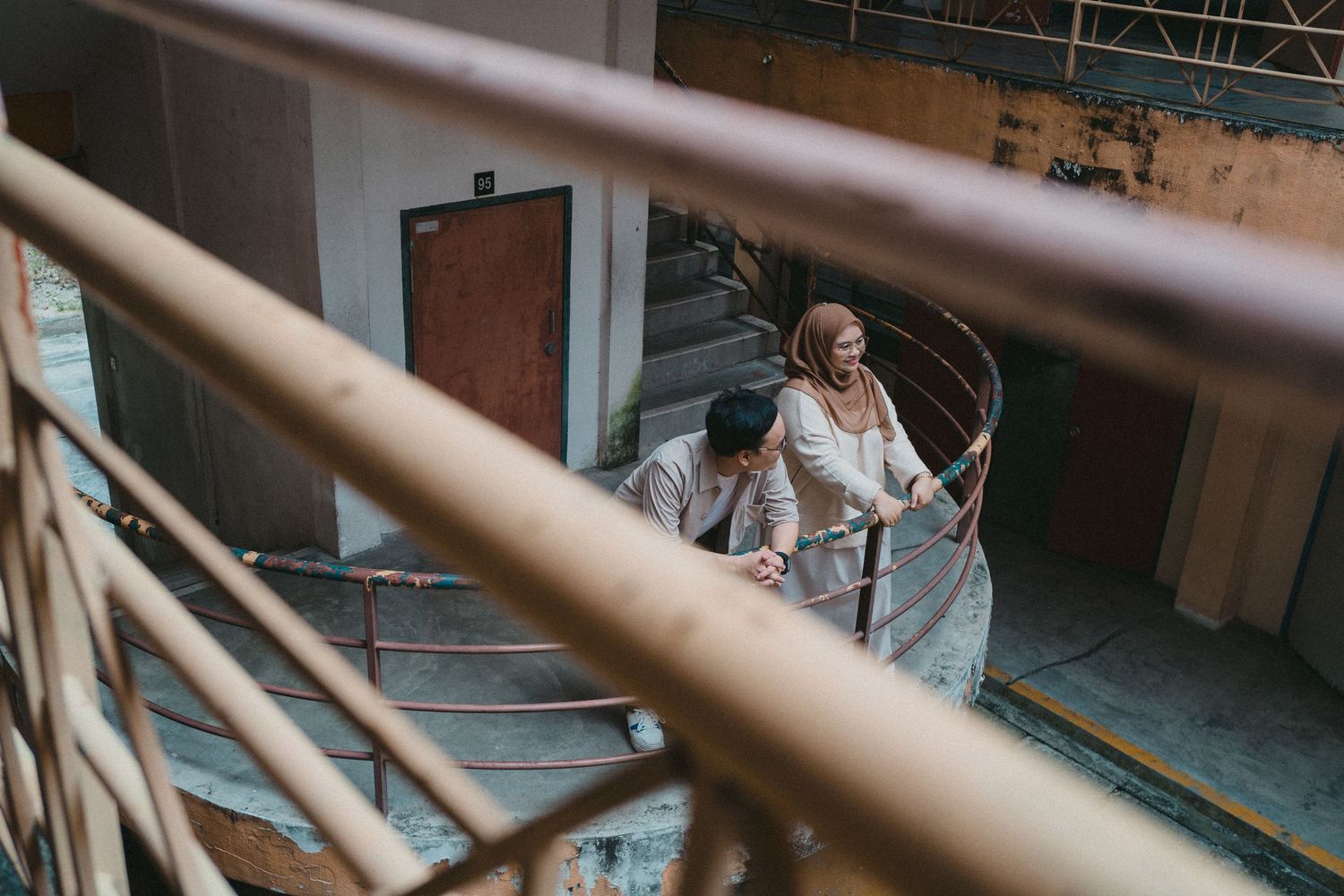 A low angle view through stair railings of a student climbing steps in a school building.