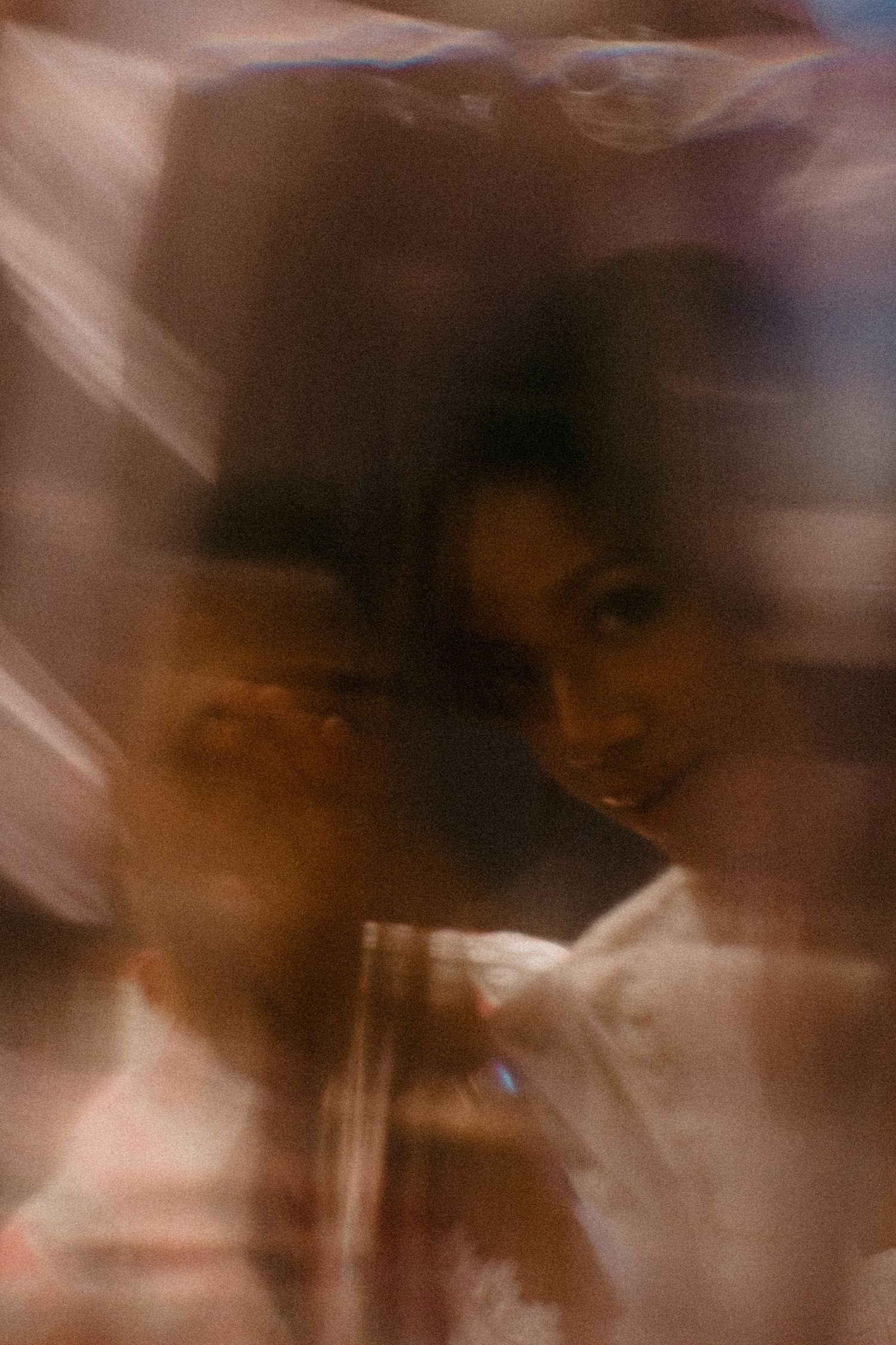 Abstract blurred portrait photo with warm brown and orange tones creating a dreamy, ethereal effect.