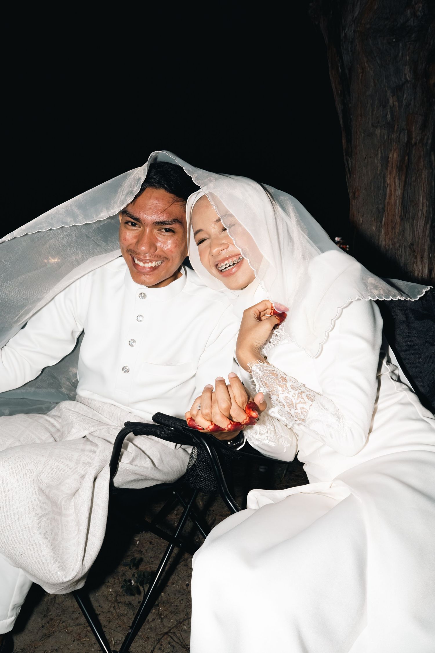 Four sequential photos show a couple in white outfits playfully interacting and laughing while seated.