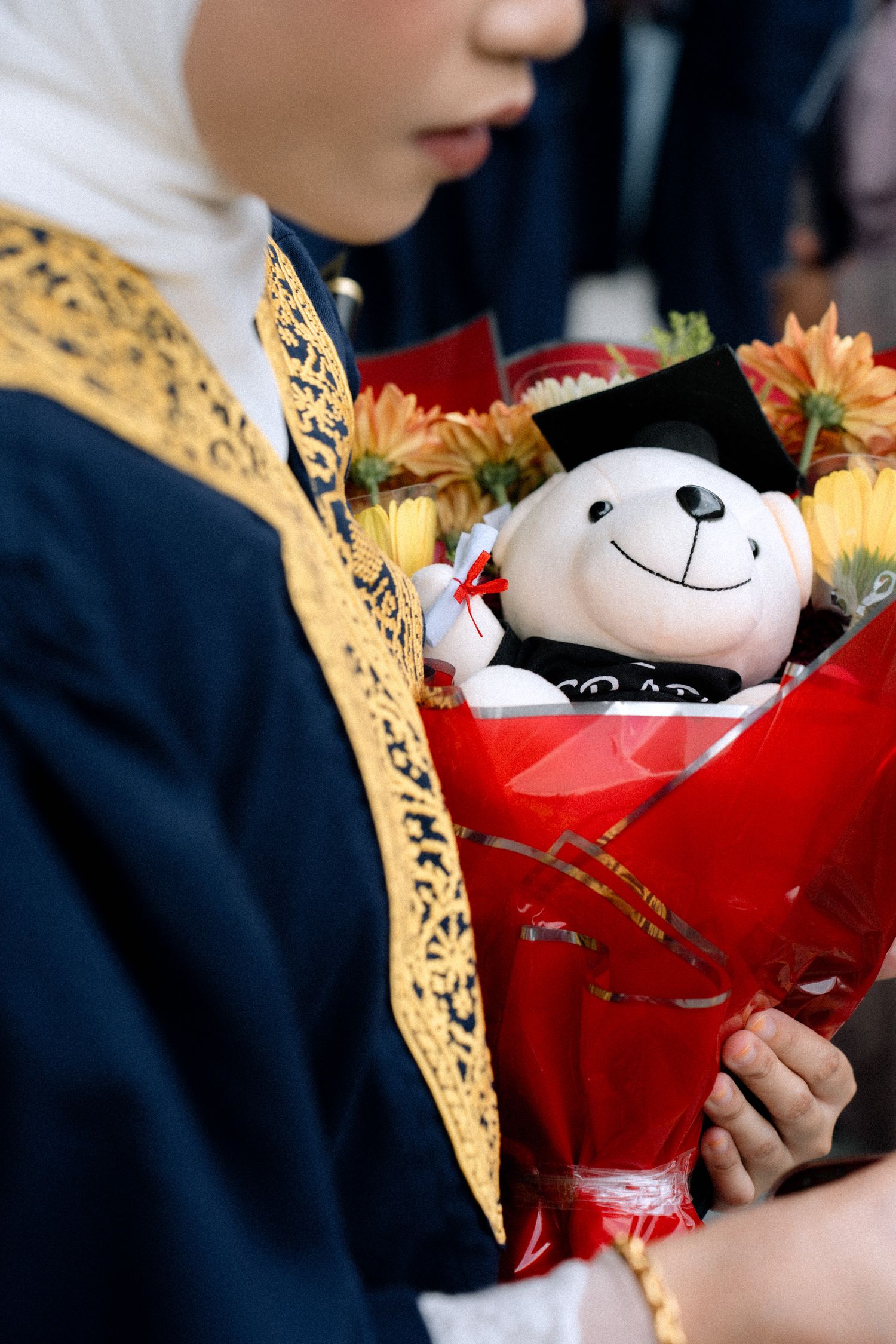 A sequence of images showing a plush toy panda being held in red wrapping paper with gold decorative accents.