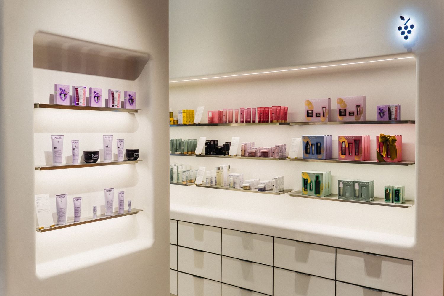 Illuminated retail shelves displaying various beauty and skincare products in organized rows.
