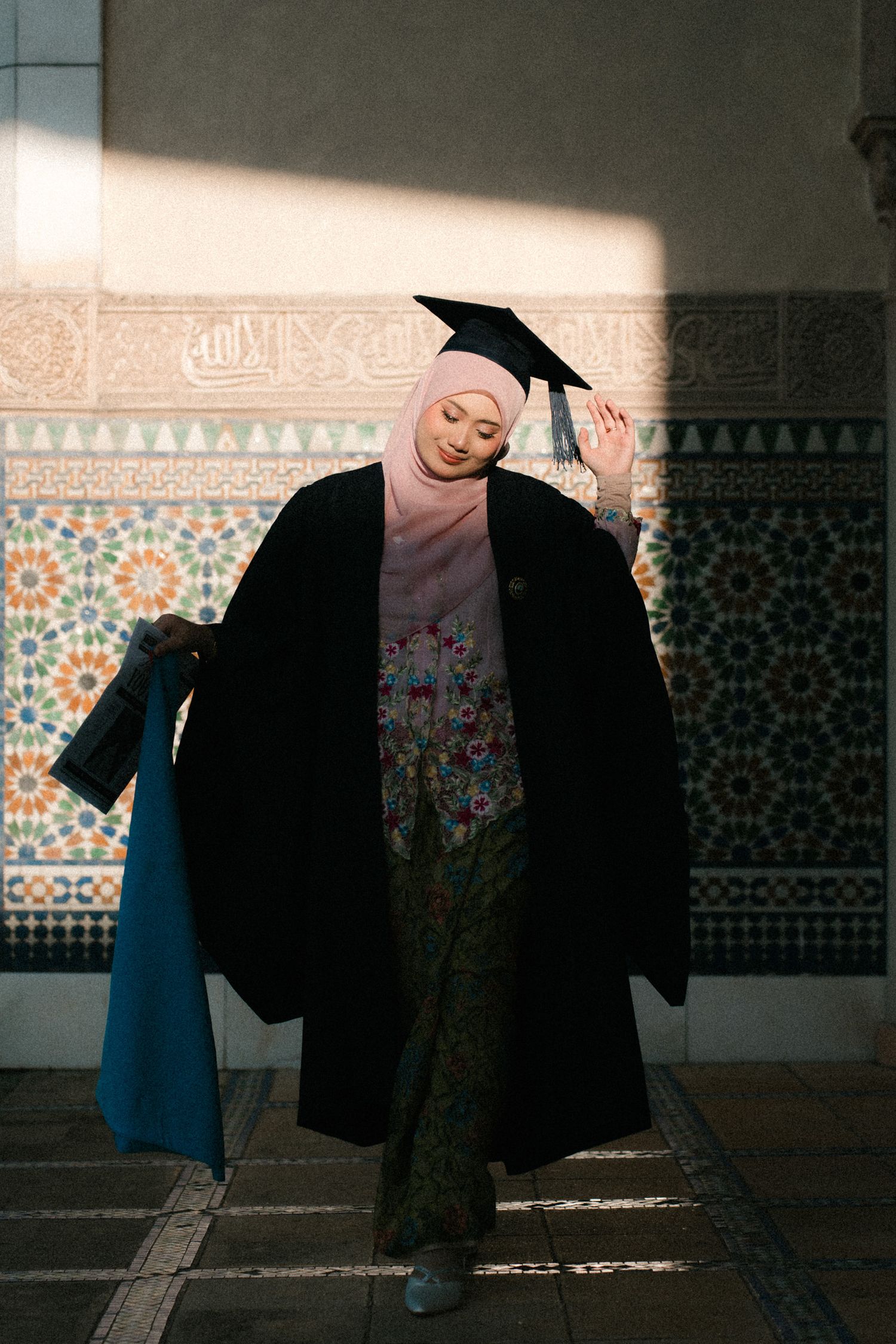 A series of four images showing a person in graduation attire dancing and posing against a decorative tiled wall.