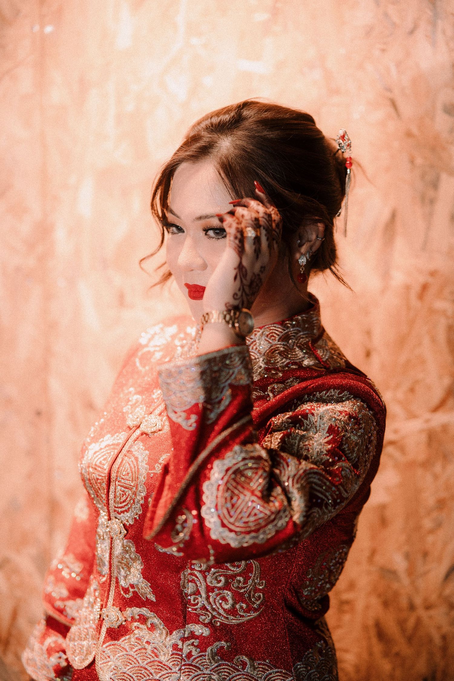 A series of artistic portraits showing a figure in an ornate red traditional Chinese qipao dress against a textured background.