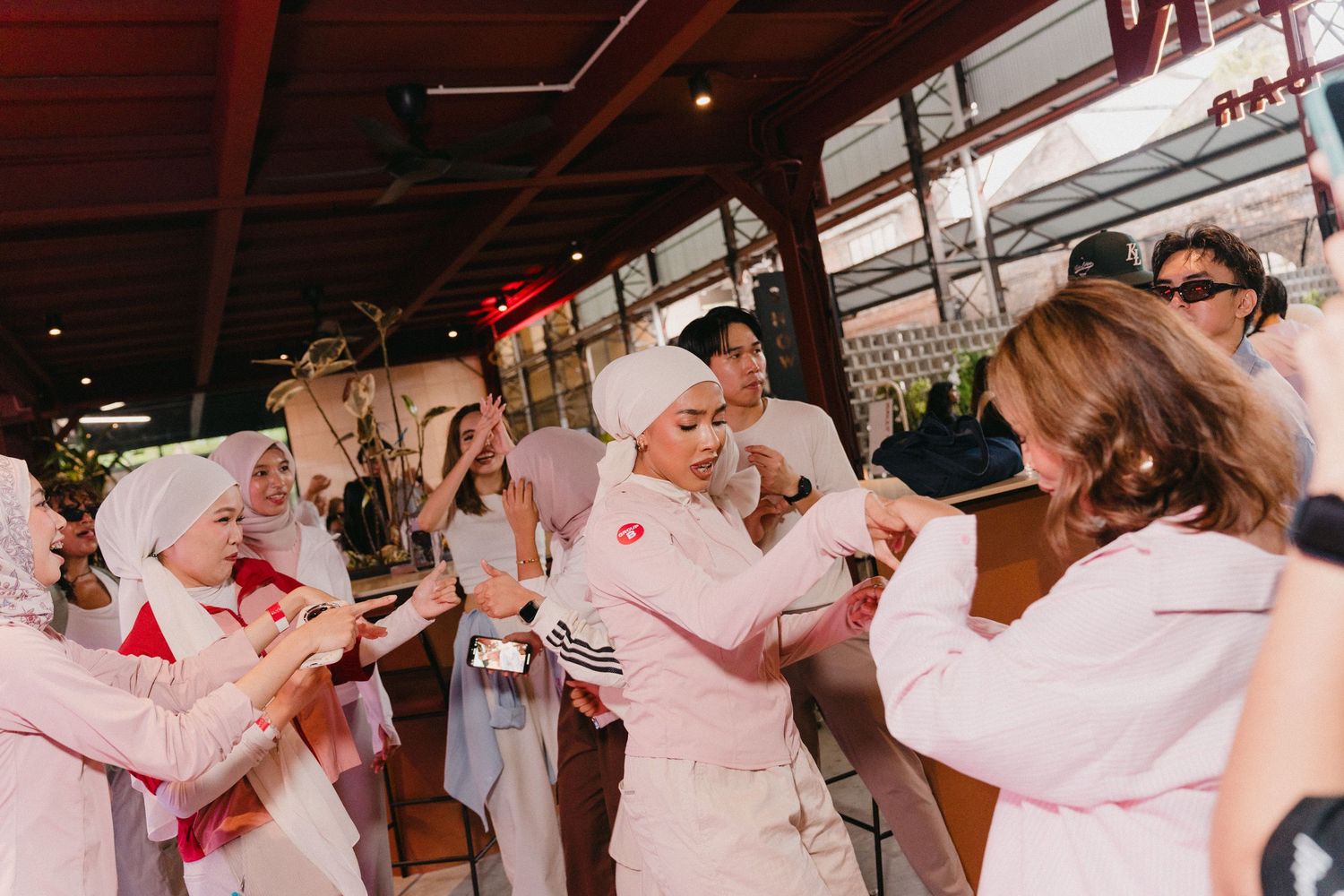 A group of people in white coats learning butchery techniques in a professional kitchen setting.