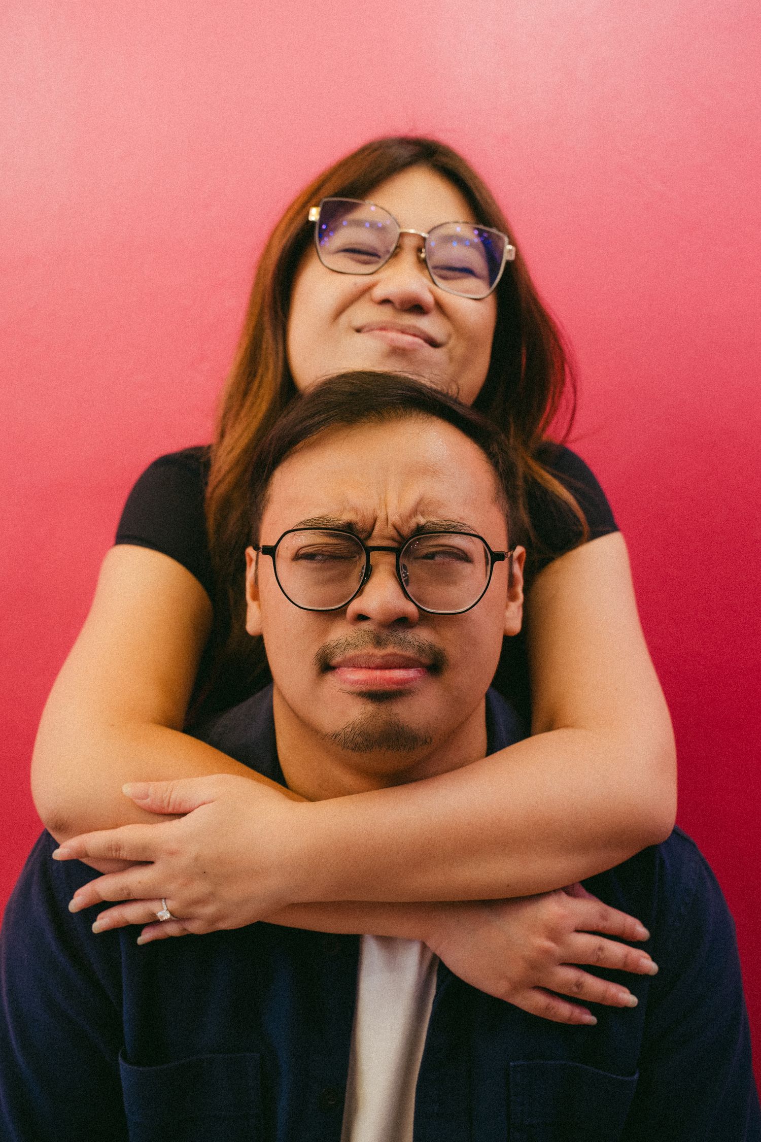 Four playful portrait photos against a pink background showing someone making silly faces while hands frame their face.