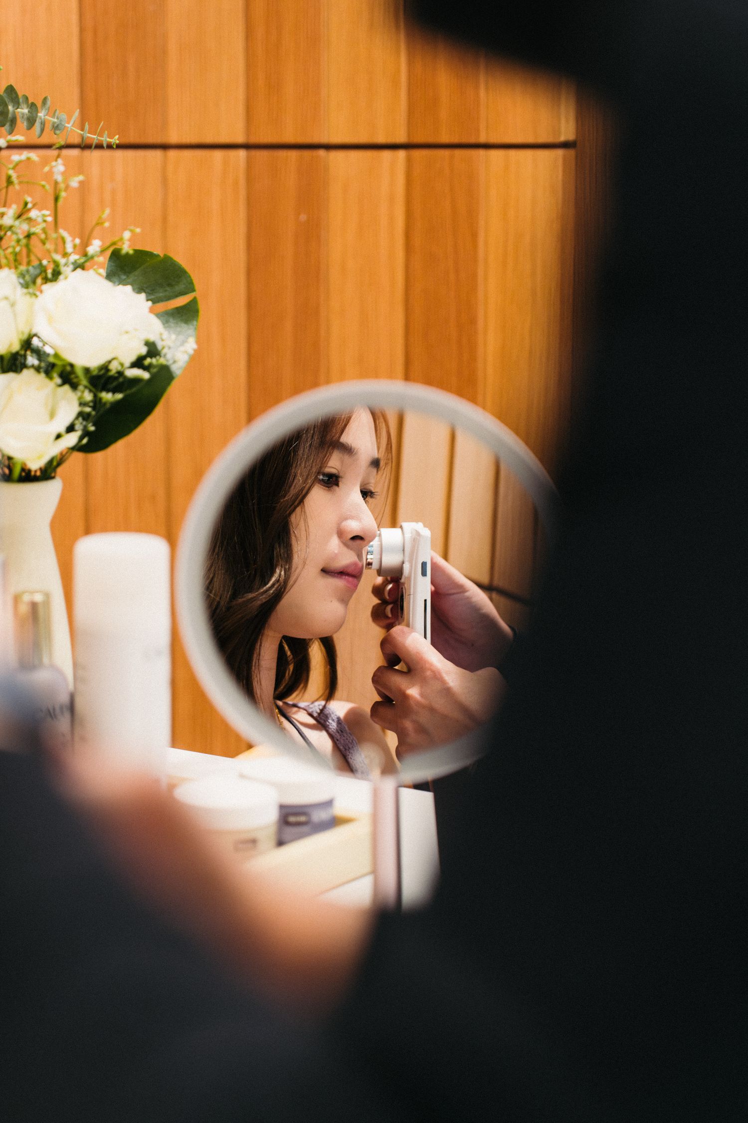 Artistic mirror reflection capturing a beauty product application moment.