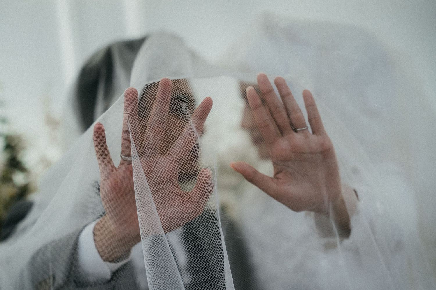 Silhouetted hands press against a foggy window glass creating an eerie atmospheric effect.