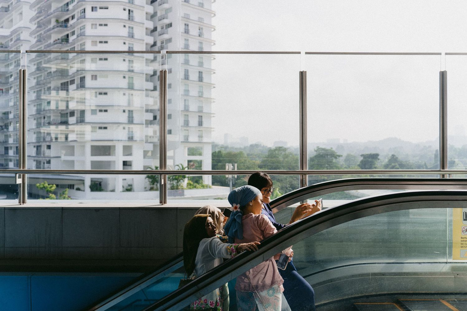 Two figures looking out over city buildings from a parking structure.