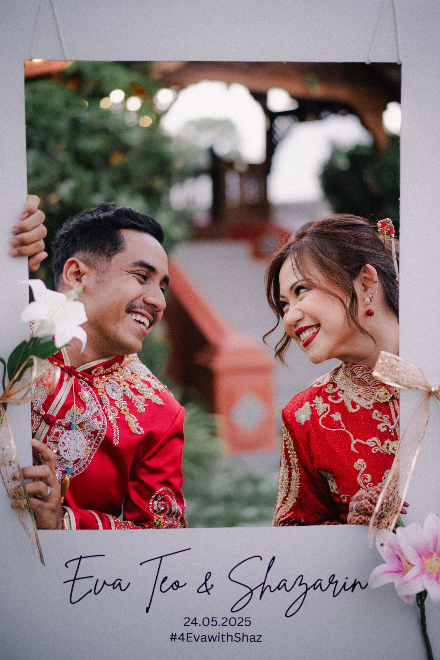 A wedding photo showing a couple in traditional red Chinese qipao dress smiling at each other against a blurred outdoor background.