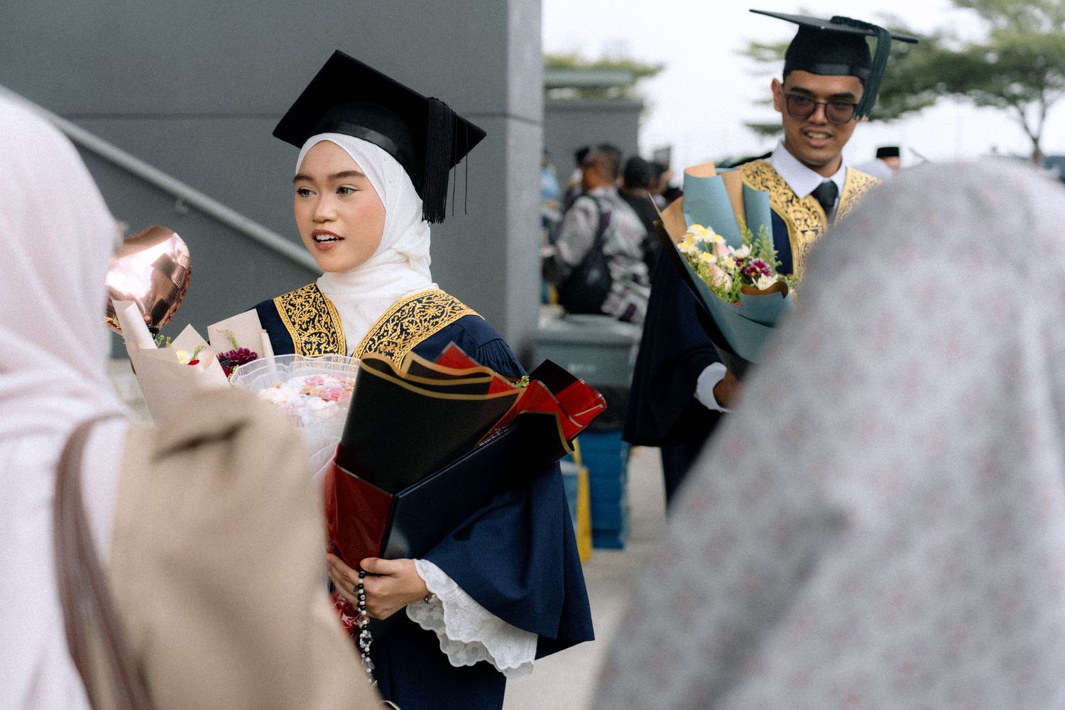 Graduates in academic regalia celebrate during a commencement ceremony with joyful expressions.