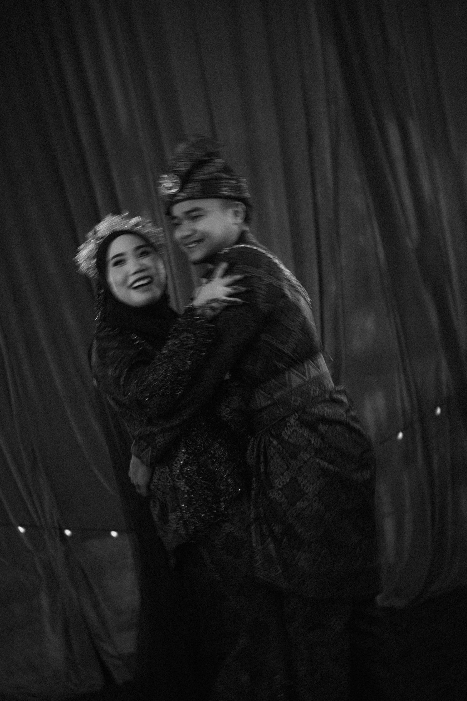 Black and white photo sequence showing two people dancing joyfully and laughing together on stage.