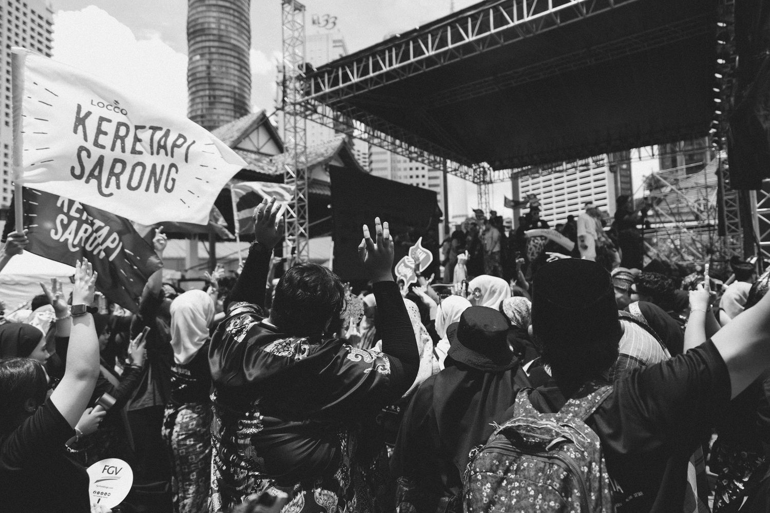 Black and white photo of crowd at rally holding signs and banners.