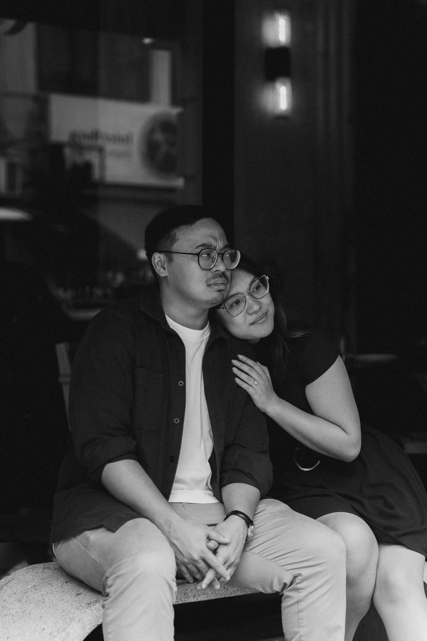 A series of black and white photos showing a couple sitting together on a couch in intimate conversation.