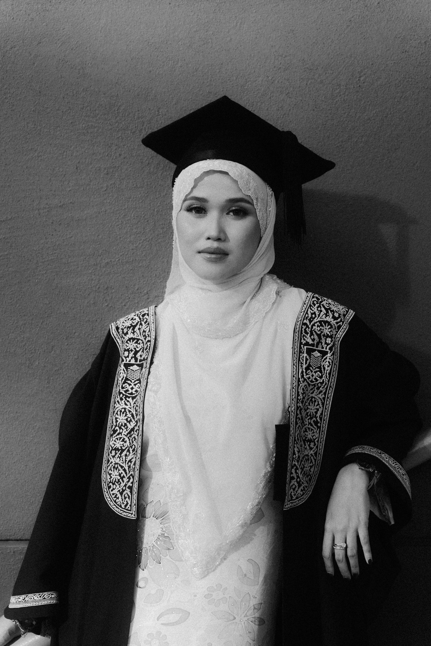 A black and white photo sequence showing a person in graduation attire and white hijab from different angles.