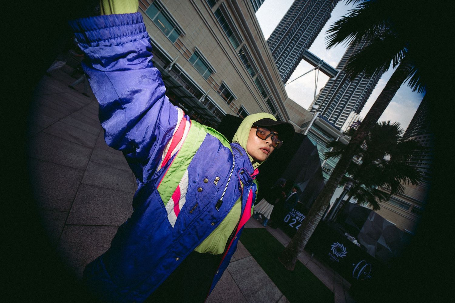 A fisheye lens shot of someone wearing colorful retro athletic wear against an urban backdrop.