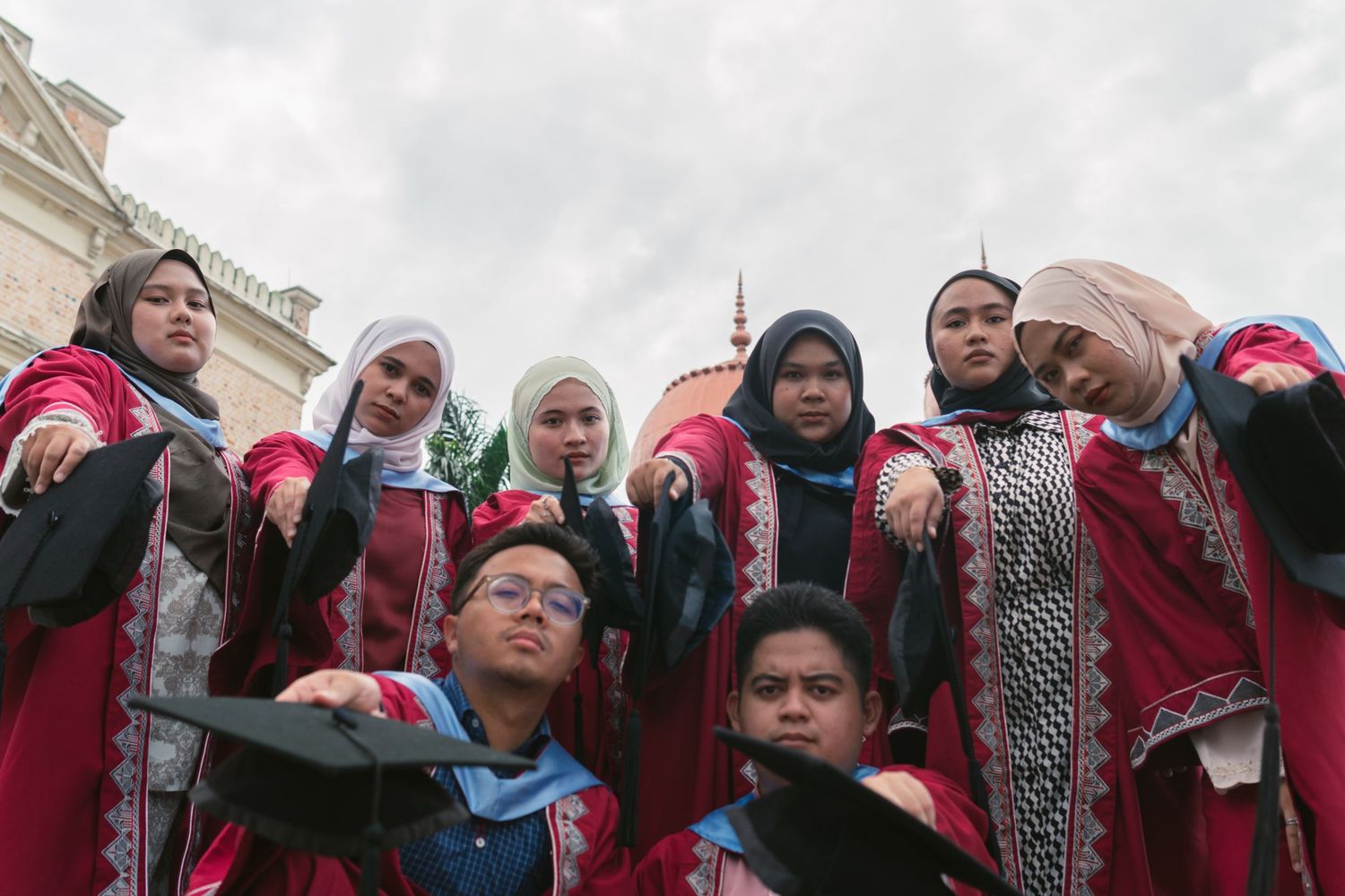 A group wearing traditional red and white garments standing together at graduation.