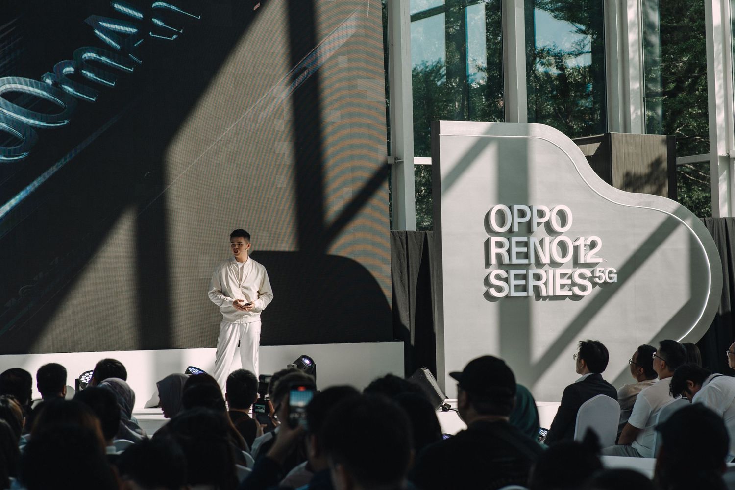 Product launch presentation with stage and audience at OPPO Reno2 series event.