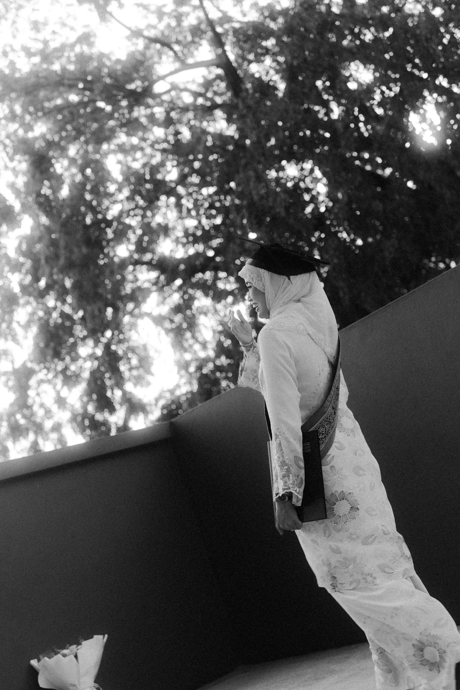 A romantic black and white wedding photo sequence showing a couple embracing under trees with flowing veil movement.