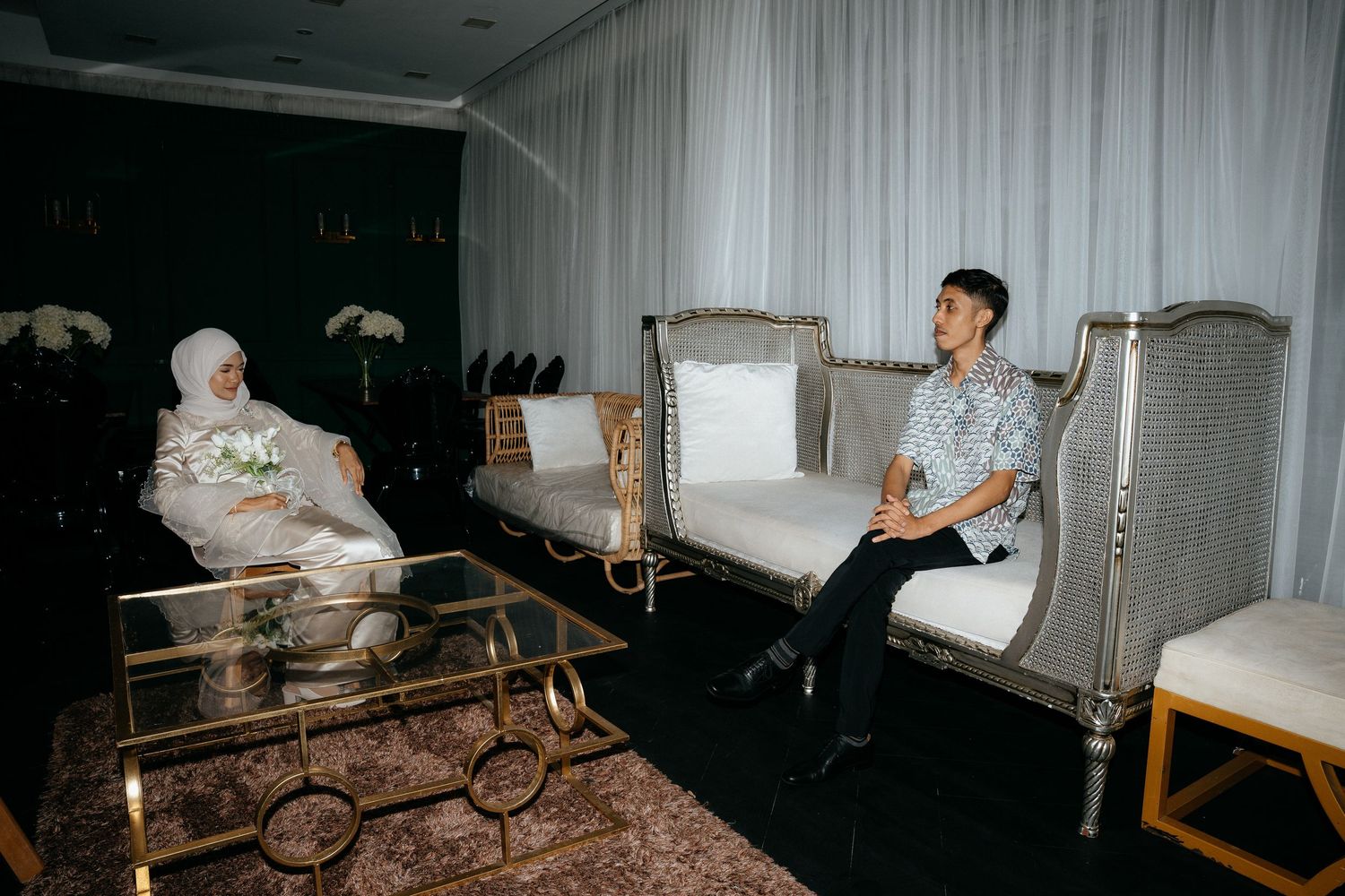 Two people relax in hospital-style beds with medical equipment in a dimly lit room with vintage flash photography aesthetics.