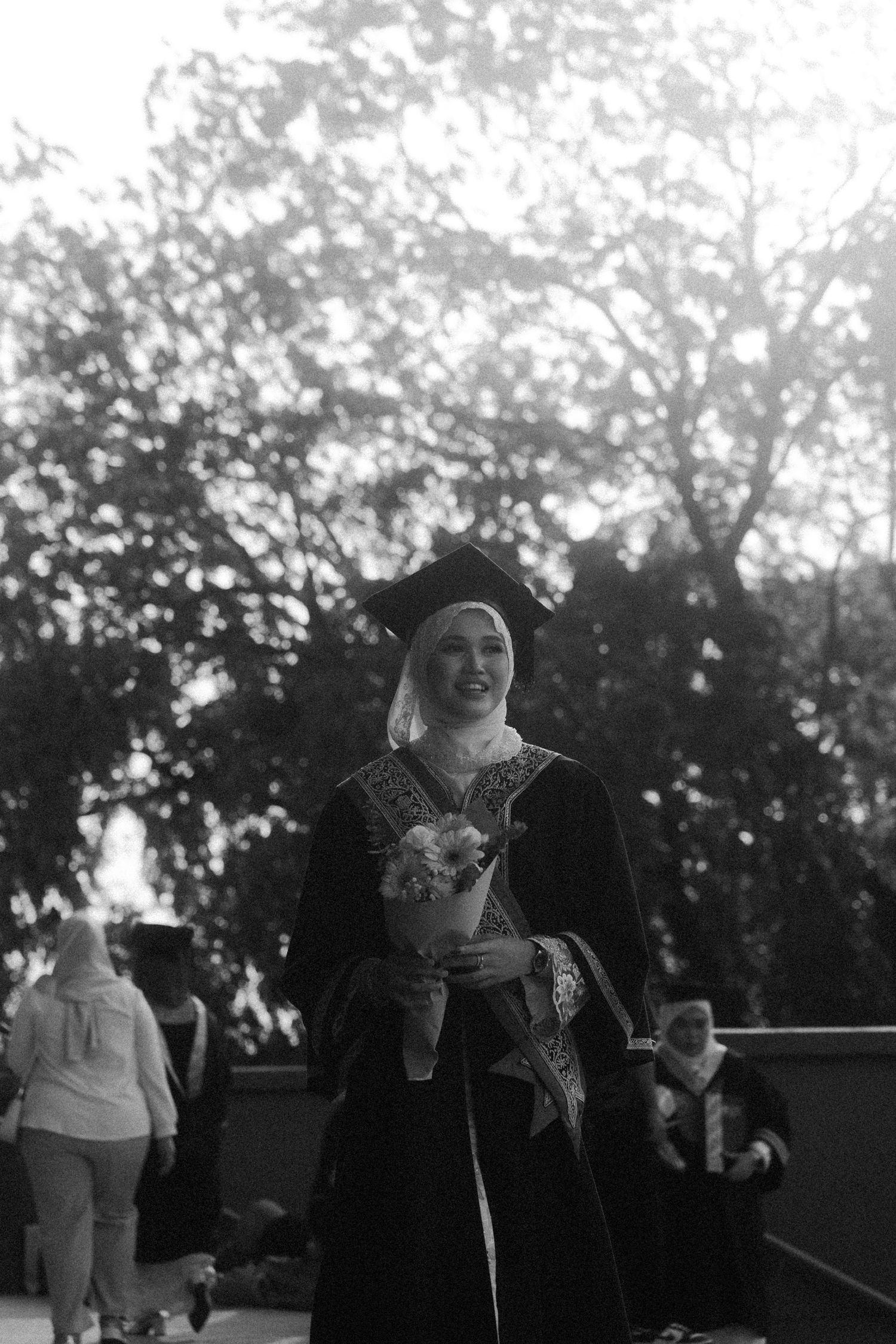 A series of black and white photos showing joyful expressions and laughter in an outdoor setting.