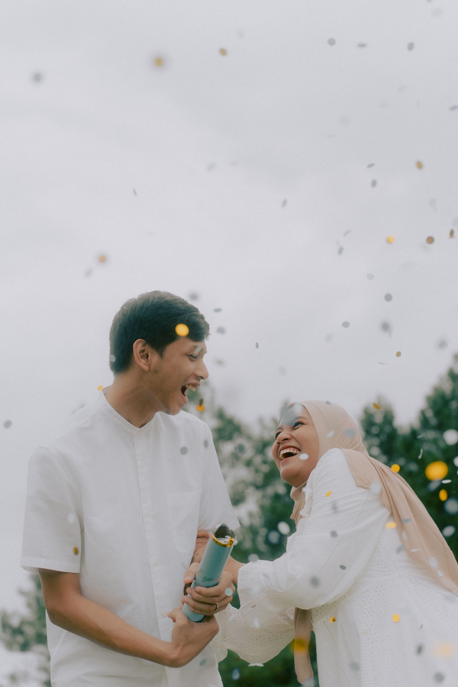 A joyful moment captured with confetti and laughter in an outdoor setting.