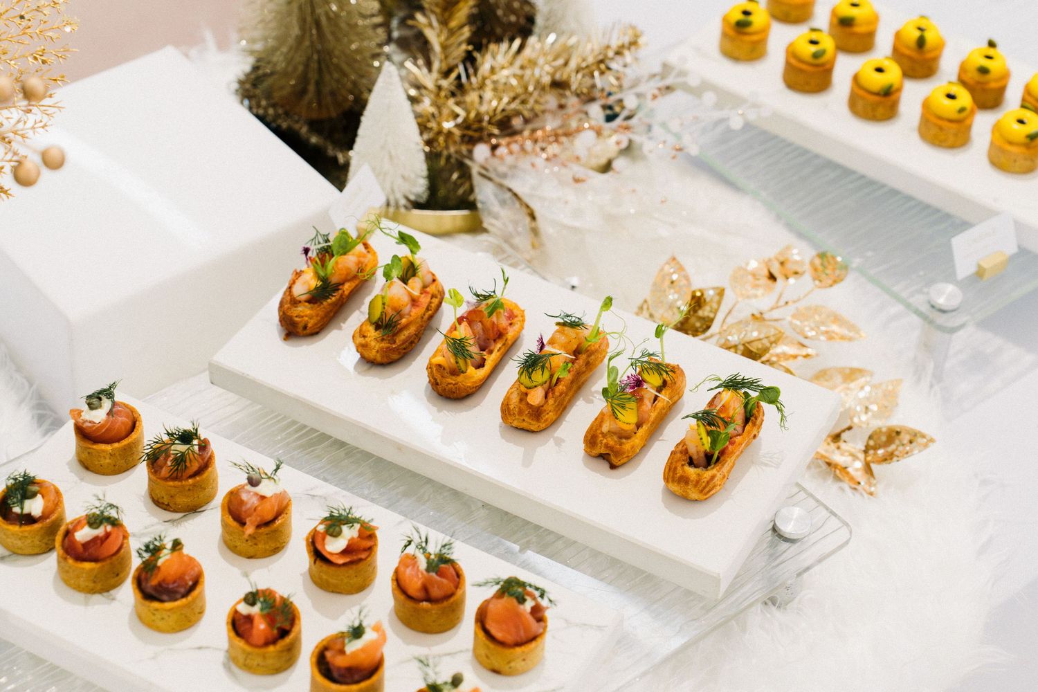 Elegant catering display of gourmet appetizers arranged on white serving plates.