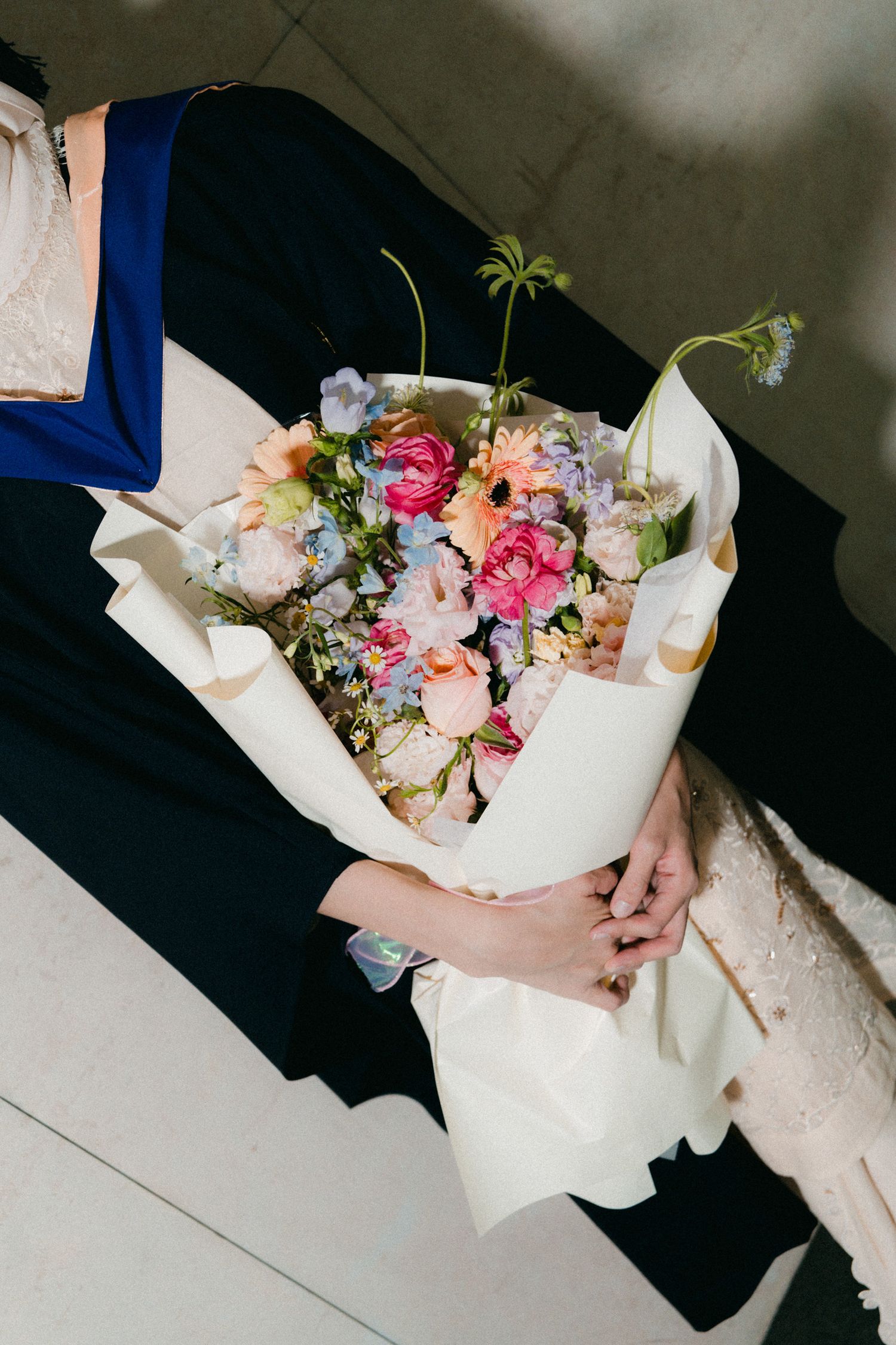 A series of images showing hands holding a beautiful bouquet of pink and white flowers wrapped in white paper.