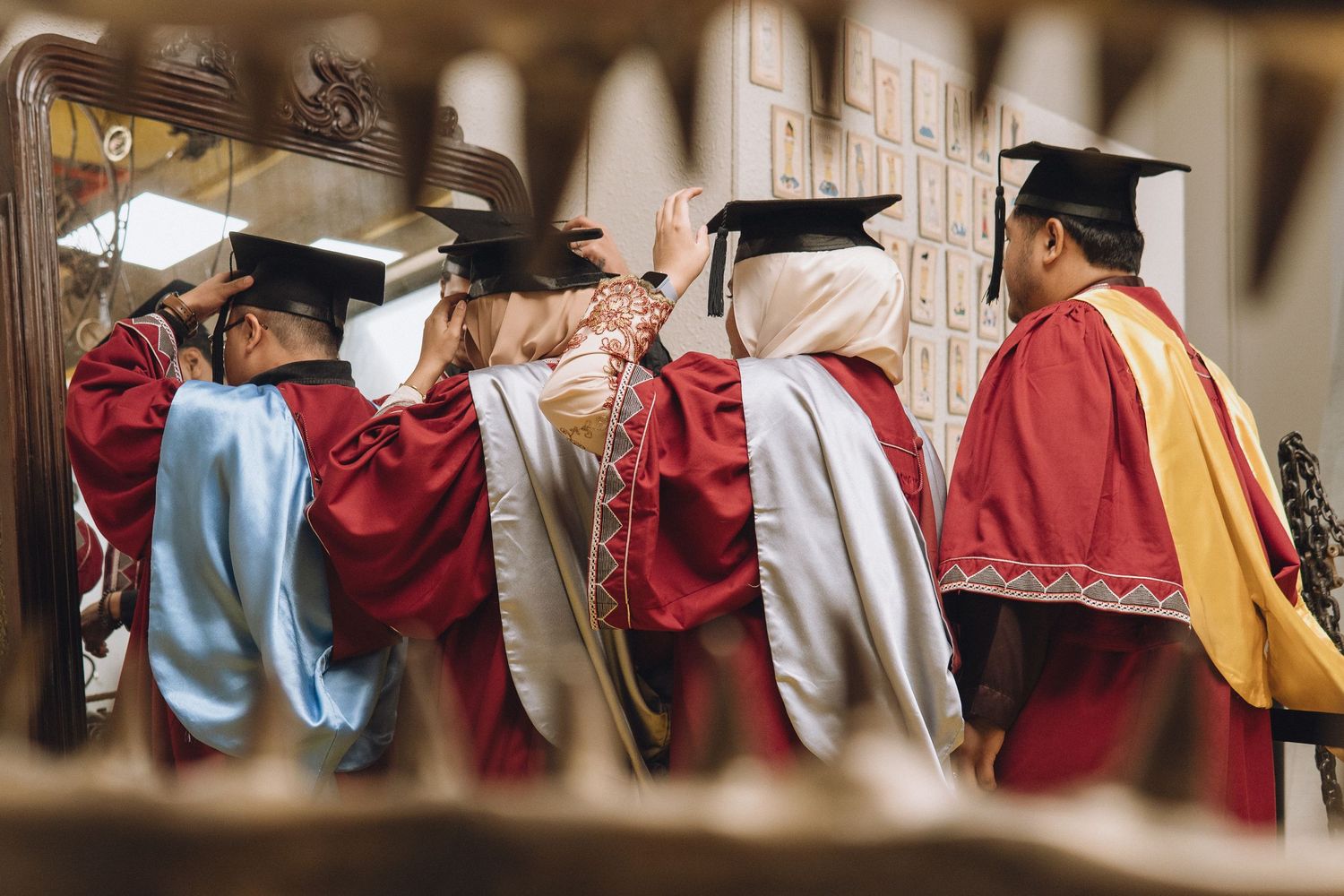 Graduates in red and blue regalia gather for a group photo during commencement ceremony.