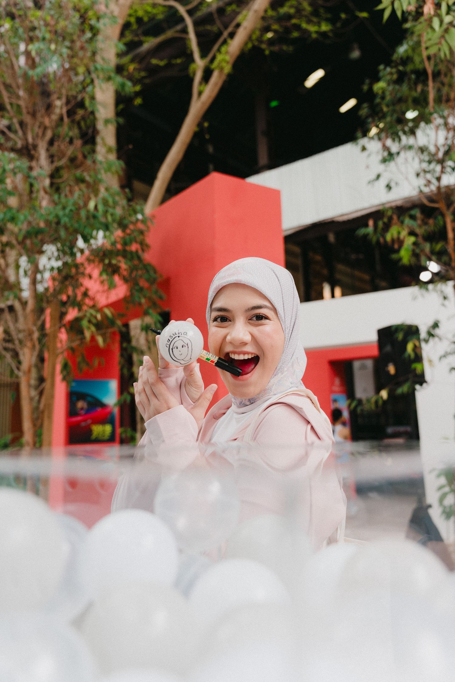 A series of playful photos showing someone in white hijab and pink outfit surrounded by fluffy white clouds or cotton.
