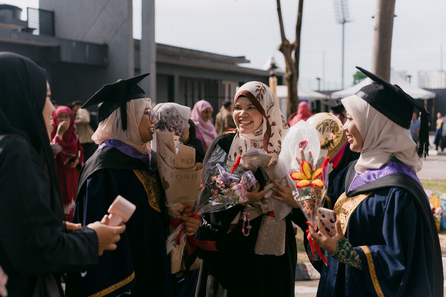A group of people in traditional headscarves gather together in what appears to be a social or community event setting.