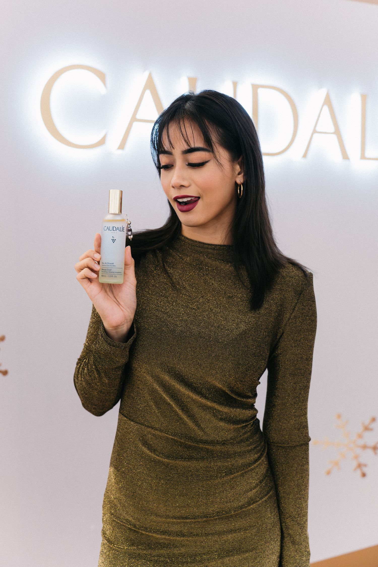 Beauty product showcase in front of illuminated Caudal logo signage.