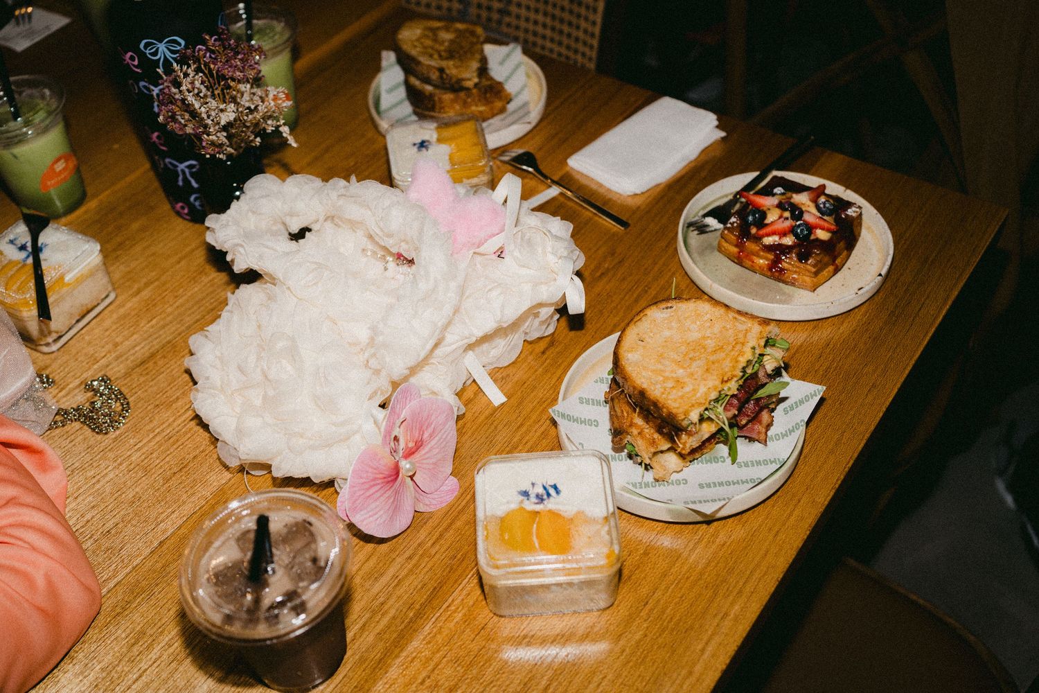 Table spread with various food items including sandwiches and desserts.