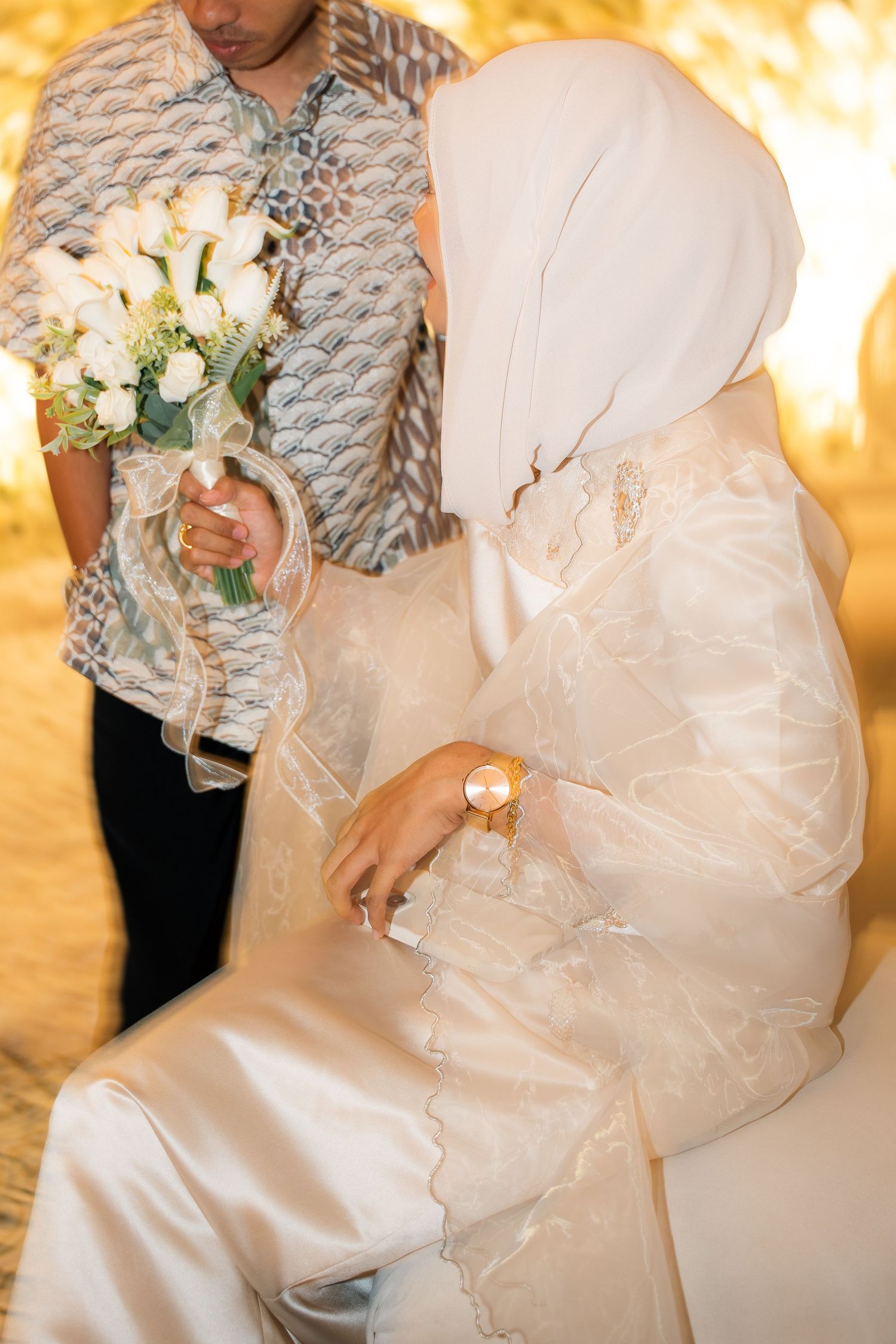 A series of wedding dress detail shots showing white satin fabric, floral bouquet and delicate lace in warm lighting.