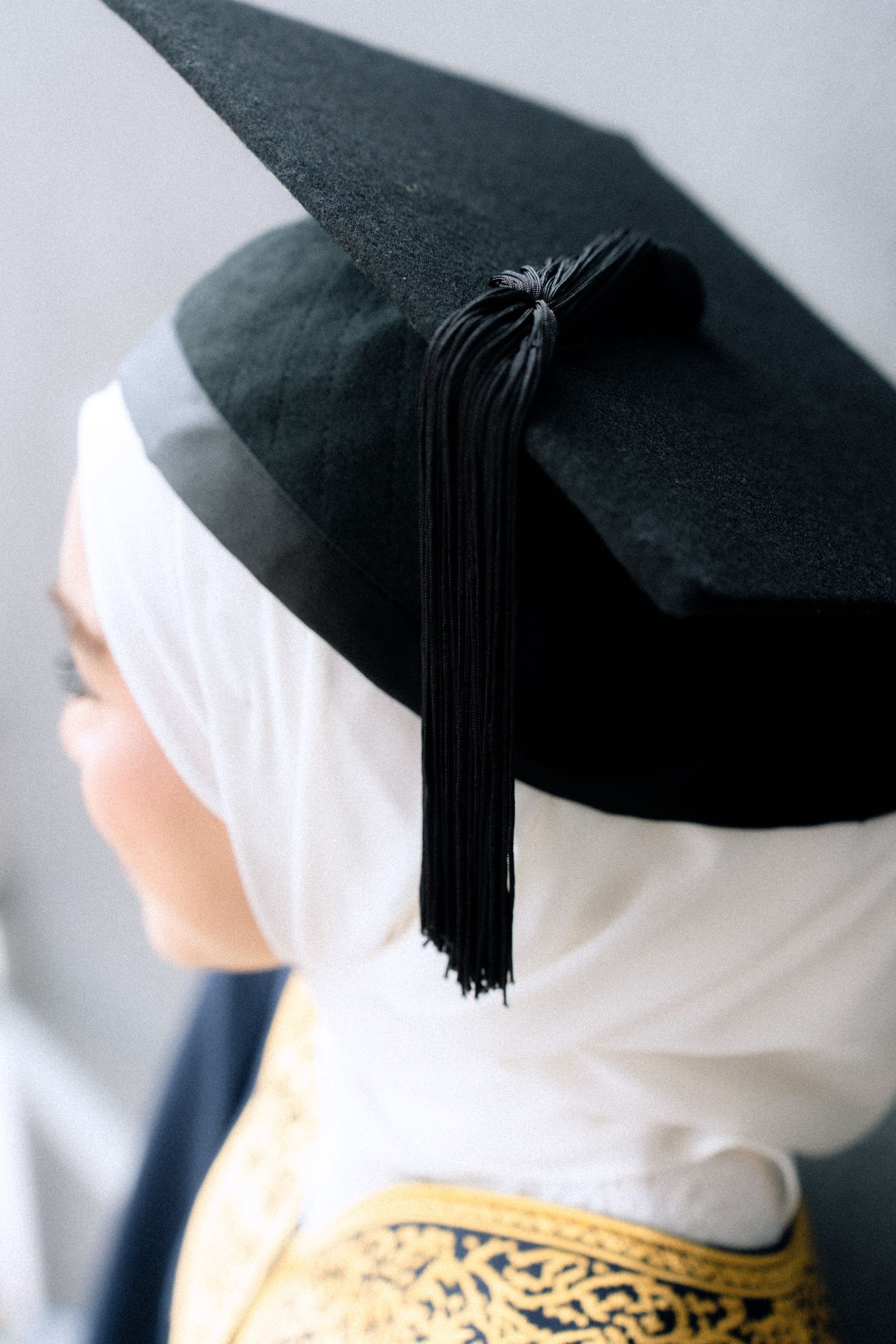 A series of profile shots showing a black graduation cap with tassel against a white background.