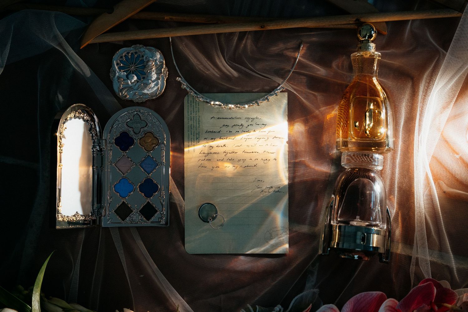 An old oil lamp and stained glass windows illuminate a vintage letter in dramatic lighting.