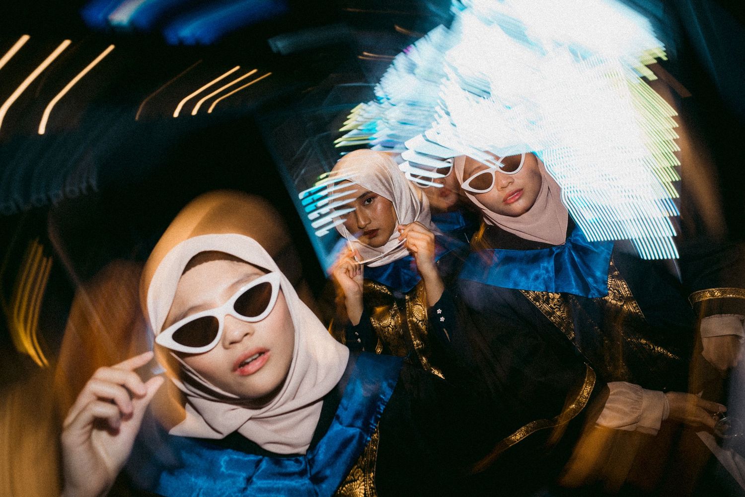 Graduates wearing white sunglasses pose in a creative fisheye lens shot.