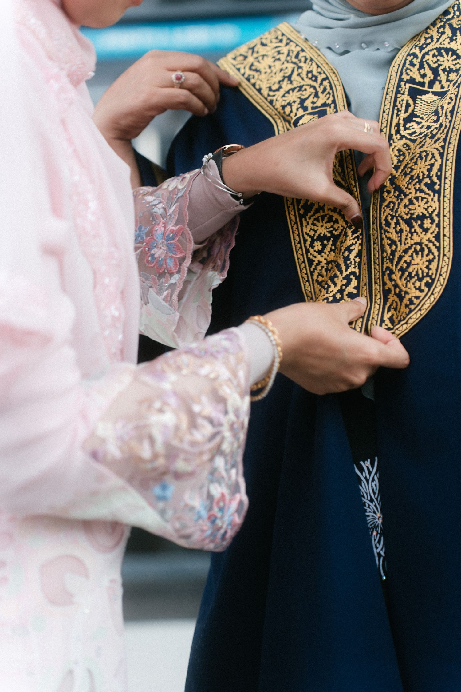 Close-up view of hands holding an ornate black and gold decorative box with intricate patterns.