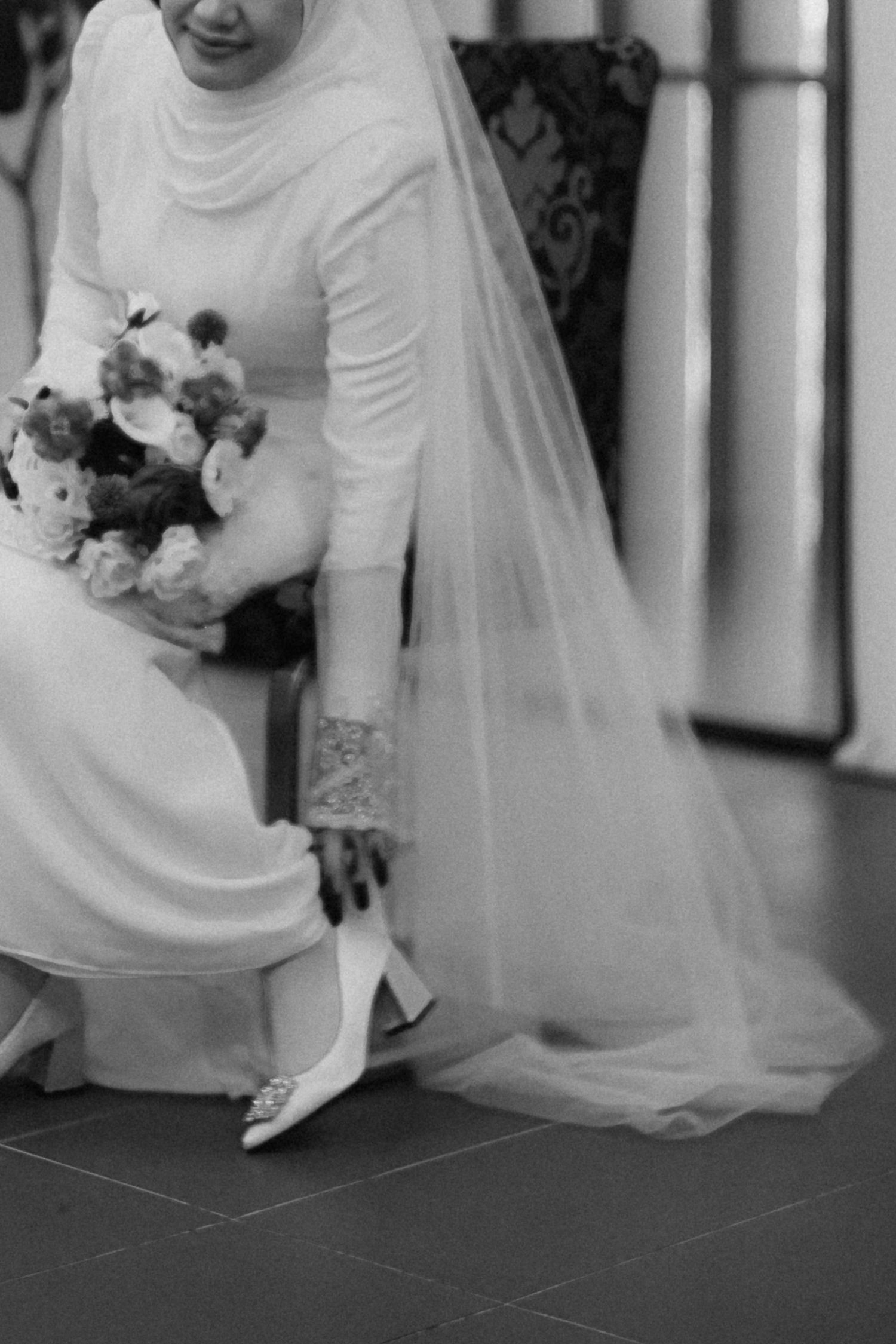 A sequence of black and white photos showing close-up details of a wedding dress and bridal bouquet.