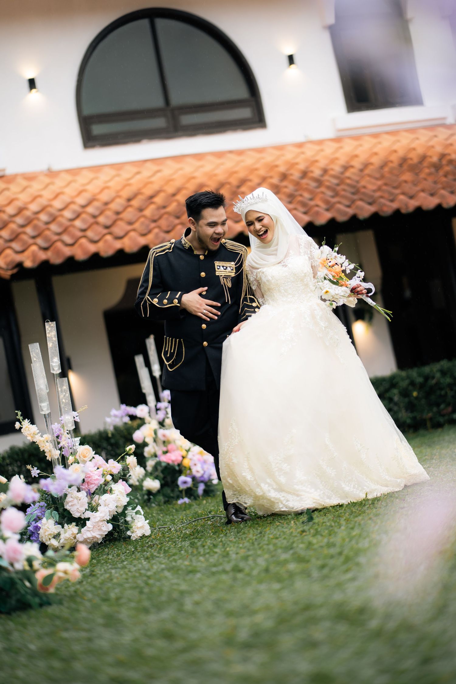 A military wedding ceremony features a couple in white dress and formal uniform walking past colorful floral arrangements.