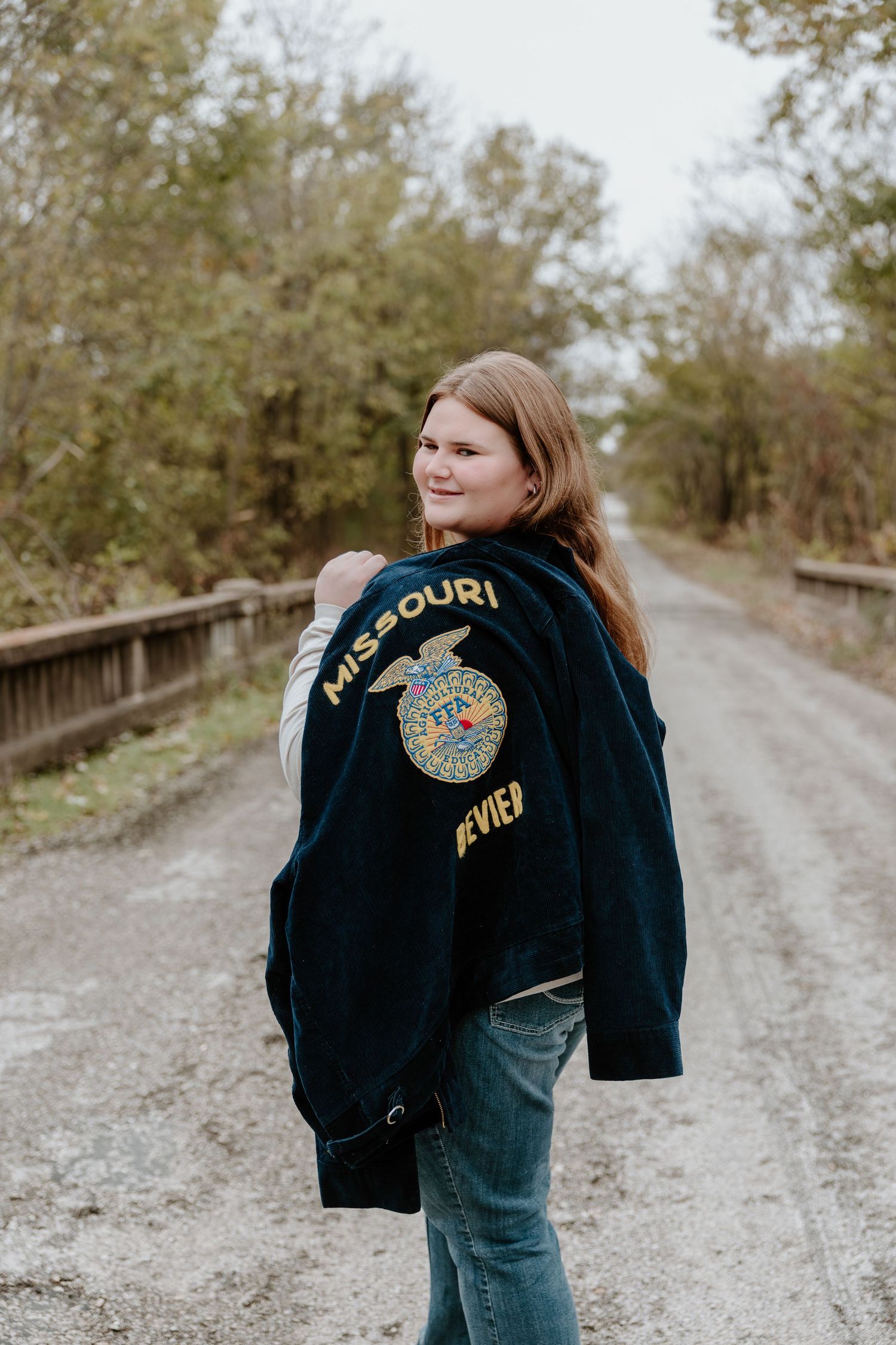A series of photos showing someone walking on a gravel path wearing a Missouri denim jacket with patches.