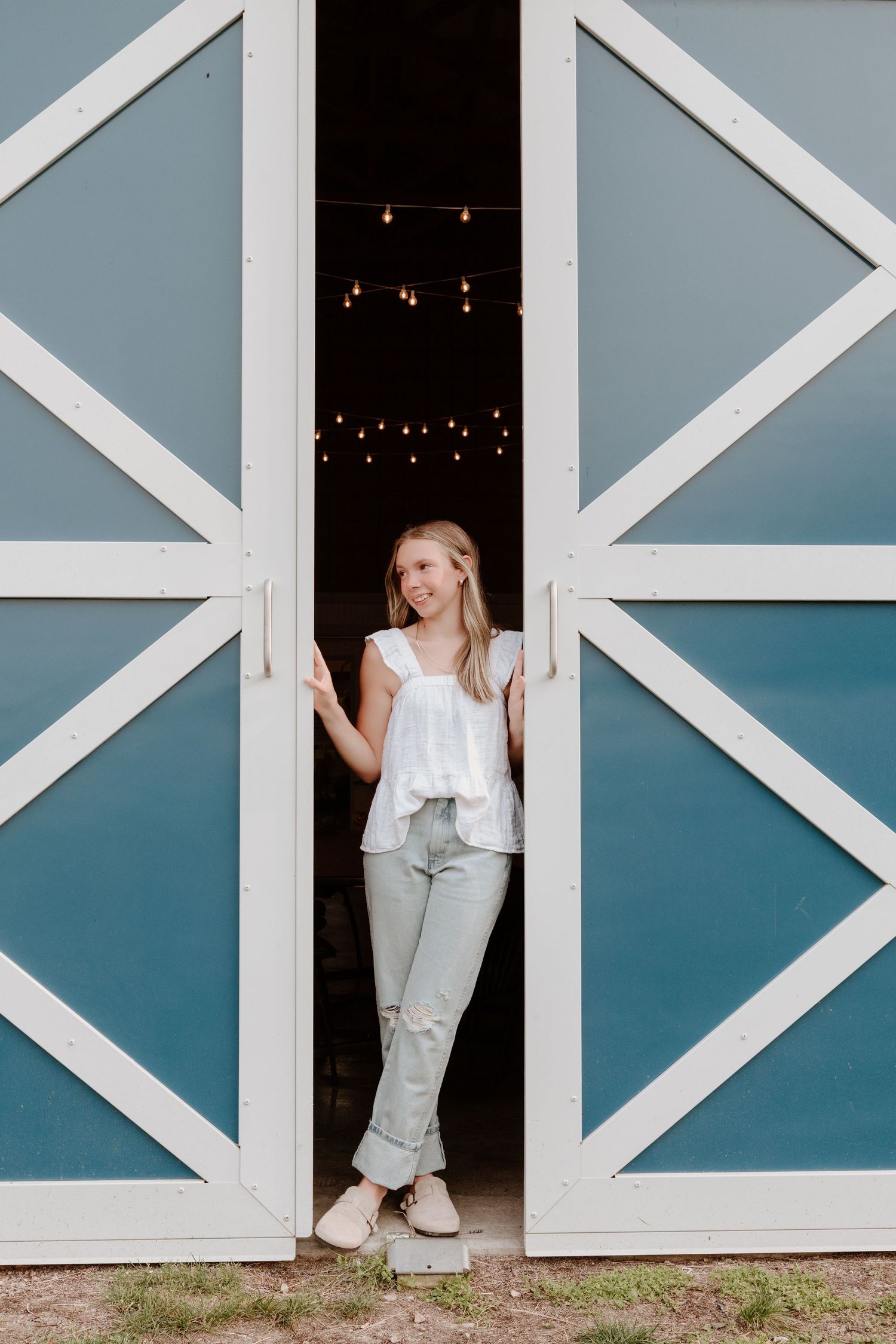 A creative triptych photo series showing someone peeking through white geometric barn doors against a blue wall.
